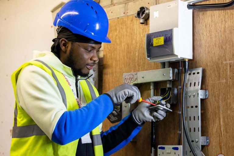 Black Man doing electrician work as a trade checking for power - Heroes United