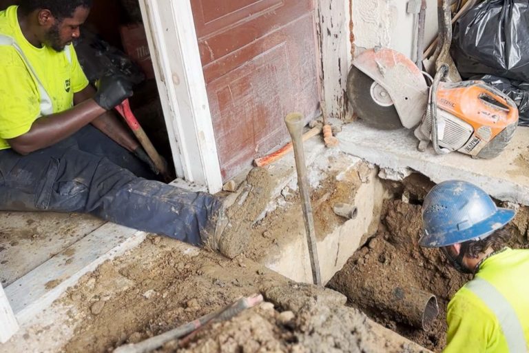 Two Roto Rooter working on a residential home
